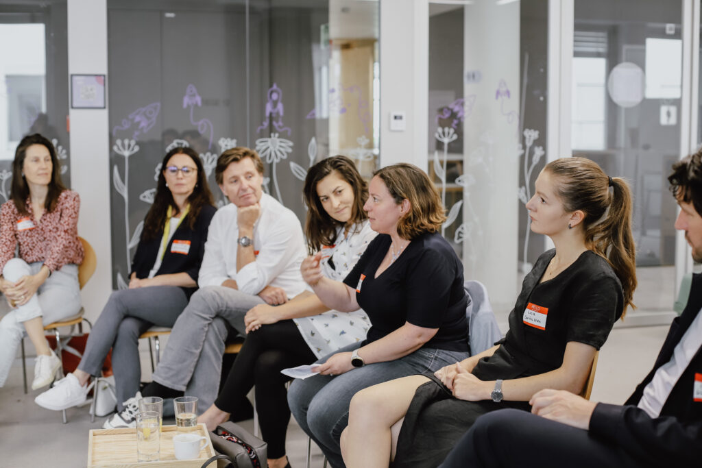 Gruppe an Menschen aus einem der letzten Workshops, die miteinander sprechen.